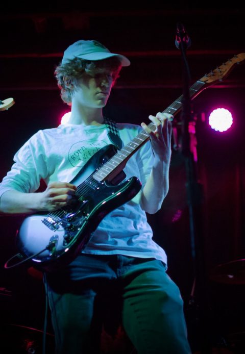 man in white dress shirt playing electric guitar